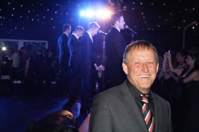 Dave smiles as Westlife performs live